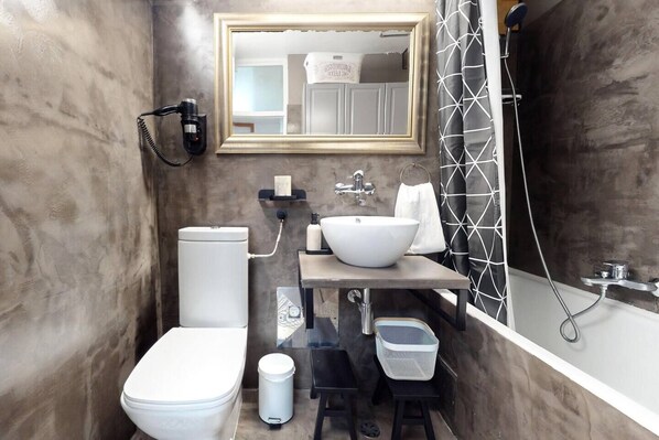 A modern bathroom with a toilet, sink, and bathtub. - Gallery Gardens Apartment (Split)
