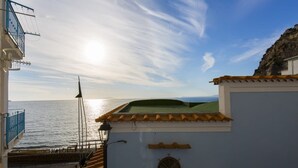 A coastal building with a view of the sea, a balcony with a railing, and a flagpole. - De Vivo Realty - Blue Angel Relais (Meta)