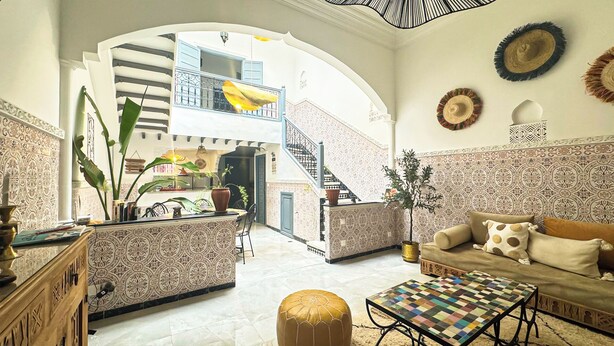 A spacious living area with a high ceiling, a staircase leading to an upper floor, and a view of a balcony. - 10 minutes from the Majorelle garden Riad Beldi Chic An Authentic Stay”- Abritel (Marrakech)