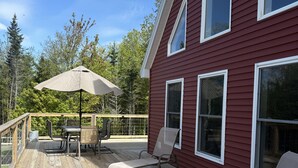 A wooden deck with outdoor furniture and a pergola.