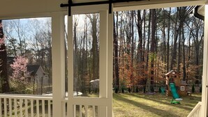 A deck with a view of a backyard featuring a wooden playhouse with a slide. - Newly built 4BR, close to Duke, ready for Duke Graduation! (Durham)