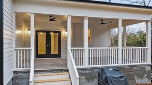 A covered porch with a set of stairs leading to a door, a ceiling fan, and a barbecue grill. - Newly built 4BR, close to Duke, ready for Duke Graduation! (Durham)