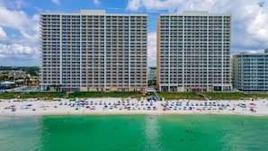 A beachfront hotel with multiple high-rise buildings, a sandy beach, and clear turquoise waters. - Majestic 2212: Gulf-View Studio with Large Balcony | Free Fun! (Panama City Beach)