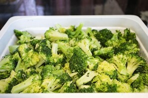 Un recipiente rectangular blanco con brócoli cocido.