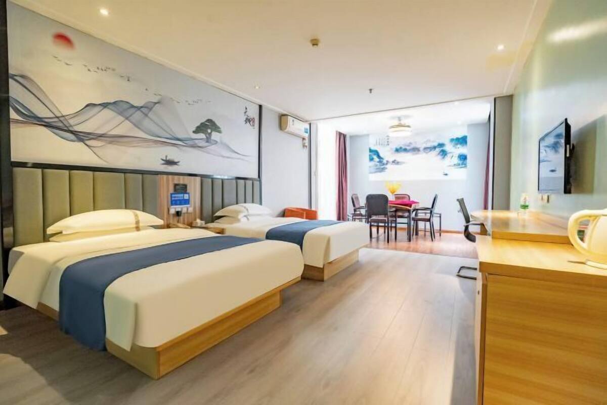 Une chambre d’hôtel avec deux lits, un bureau et un coin repas.