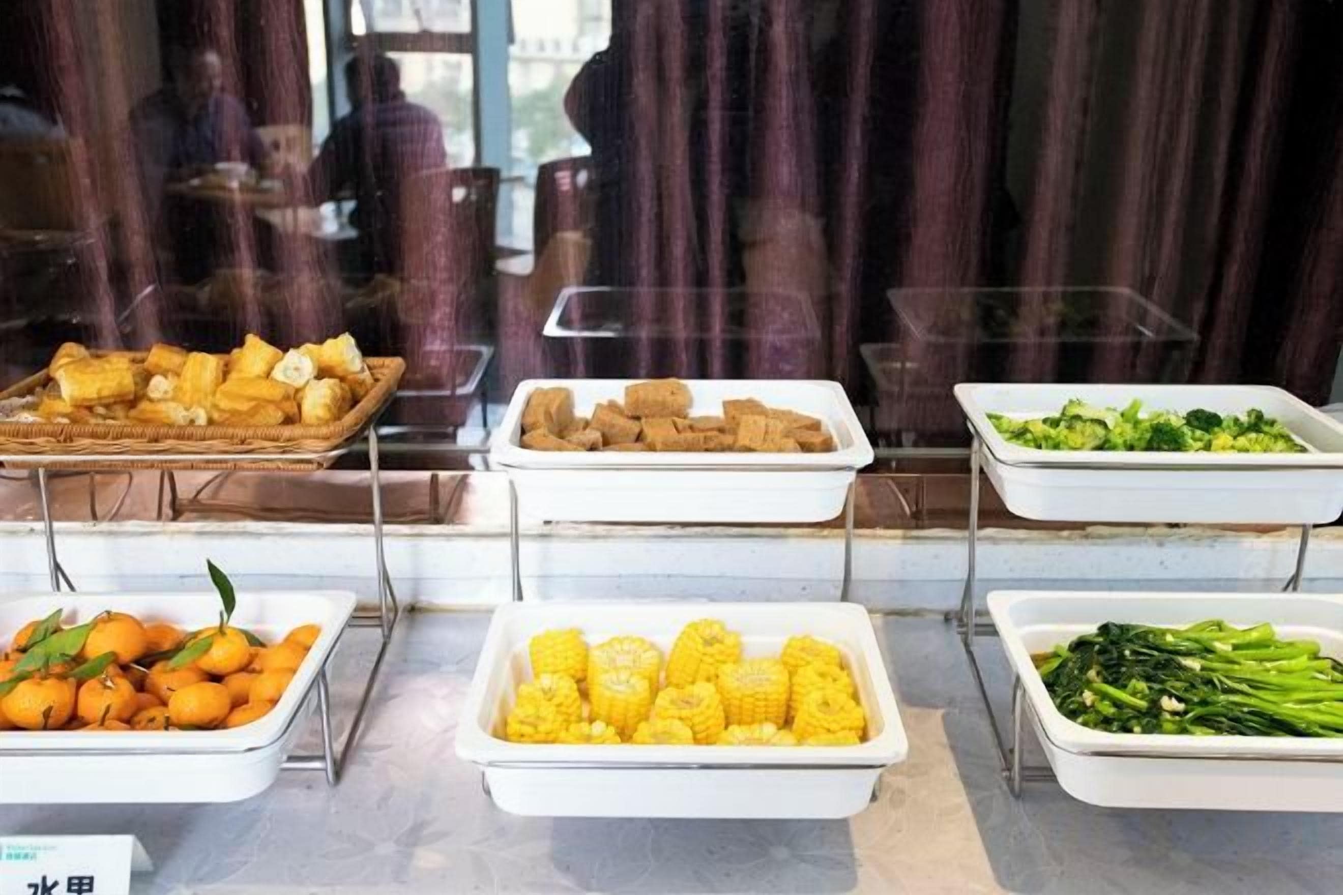 Un bufé con diversos alimentos dispuestos en bandejas.