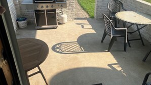 An outdoor patio with a grill, a table, and chairs. - Charming 3-bed countryside house in Northampton with WiFi and AC (Northampton)