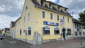 A yellow building with a restaurant sign, a stone facade, and a bike lane. - Family and Friends Dannstadt (Dannstadt-Schauernheim)
