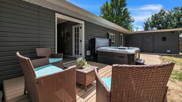 Un patio con muebles de mimbre y un jacuzzi.
