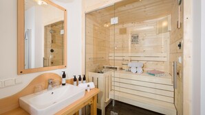 A wooden cabin-style bathroom with a large mirror, a sink, and a shower area. - Apartment Ausseerland Near Ski Slopes (Grundlsee)