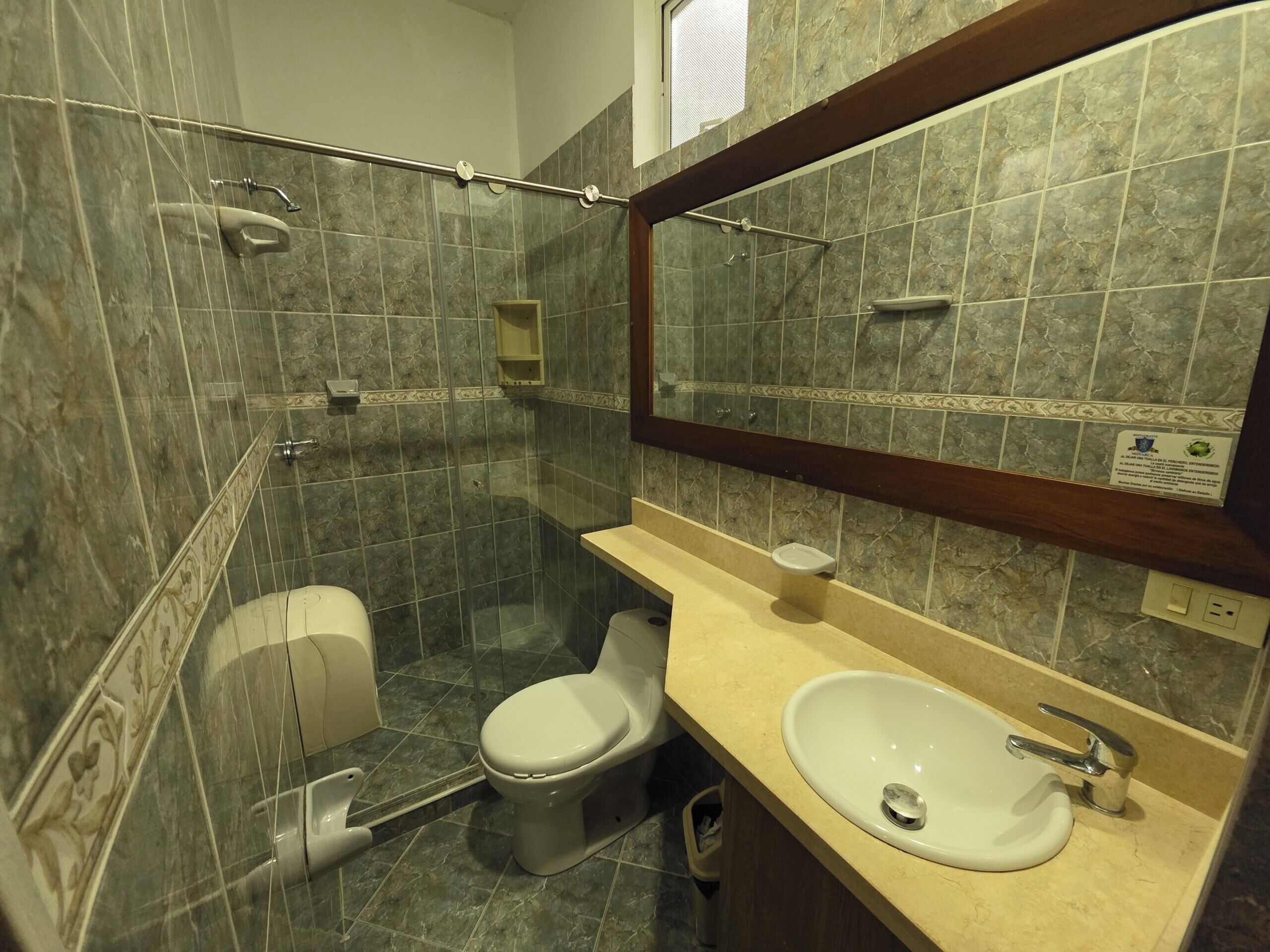 A bathroom with a shower, toilet, and sink.