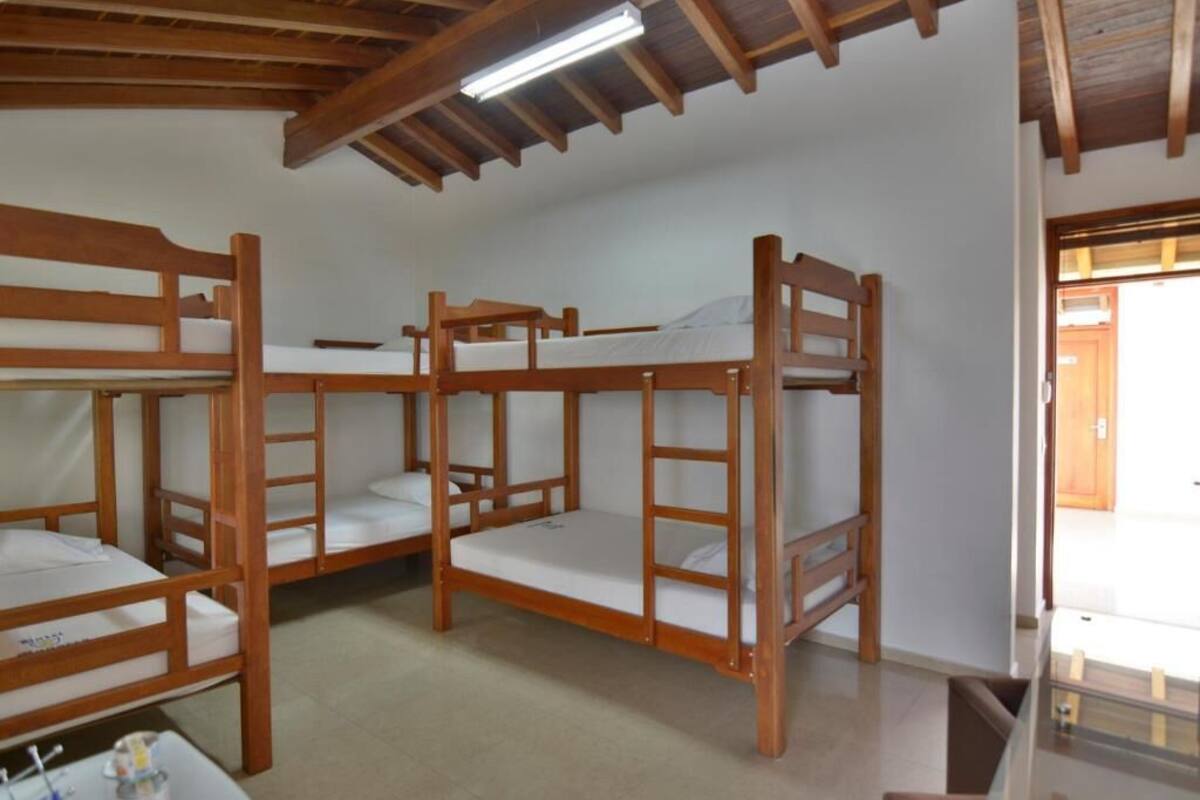 A room with bunk beds, a small table with items, and a ceiling fan.