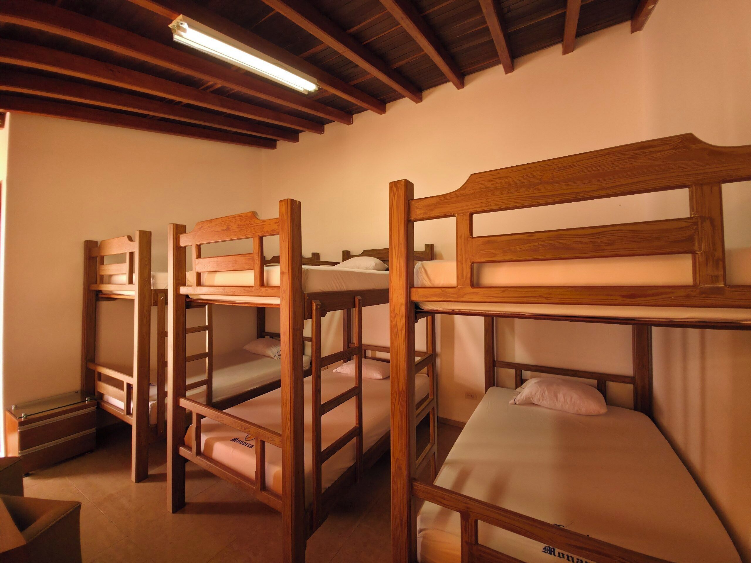 Une chambre de dortoir avec des lits superposés en bois et un bureau.