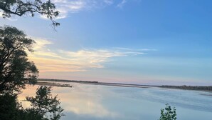 A calm river with trees on the banks and a clear sky. - Cozy RV with Expansive River Views (Newcastle)