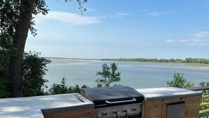 A barbecue grill with a view of a lake. - Cozy RV with Expansive River Views (Newcastle)