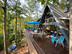 A wooden deck with outdoor furniture and a hammock.