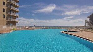 A swimming pool with lounge chairs and a view of the ocean. - Tidewater Escape: 1br/2ba Beachfront Condo, Sleeps 6, Gulf Views & Comfort! (Panama City Beach)