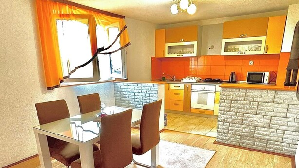 A compact living space with a dining area, kitchen, and a small living room.
