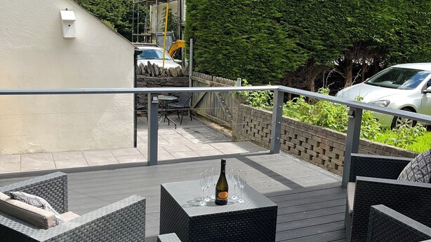 An outdoor patio with wicker furniture and a bottle of champagne. - 4-6 Guests in centre location with stunning views (Llanberis)