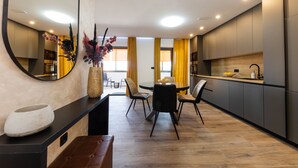 Una cocina moderna con comedor, que incluye una mesa redonda, sillas y un espejo grande.