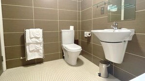 Un baño moderno con inodoro, lavabo y toallero.