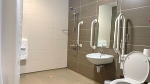 A modern bathroom with a shower, sink, and toilet.
