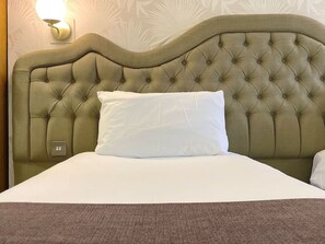 Restful retreat with a tufted headboard and plush bedspread.