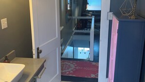 A bathroom with a white sink, a blue cabinet, and a patterned rug on the floor.