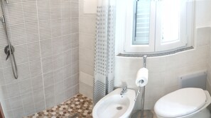 Een haardroger, een bidet, handdoeken, toiletpapier