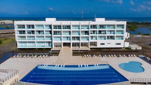 A modern hotel with a large pool, multiple balconies, and a view of the ocean. - Charming 2-bedroom house in Puerto Velero with WiFi, fitness room, AC (TUBARA)
