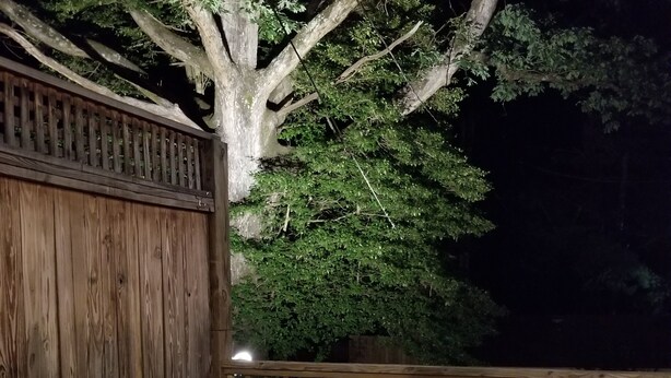 Una vasca idromassaggio con due bicchieri di vino, un telecomando e una sedia.