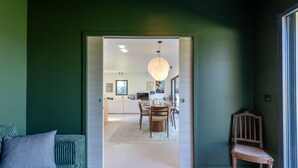 A modern interior with a dining area, a sofa, and a chair. - L'Élégance | 115 m² | 4 + 2 guests | Design & Nature (Honfleur)