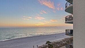 A beachfront view from a balcony overlooking a sandy beach and ocean, with a clear sky and a sunset. - Watercrest Waves! Beachfront 2br/2ba Condo, Sleeps 8, Stunning Gulf Views! (Panama City Beach)