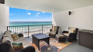 A balcony with wicker furniture, a small table, and a view of the beach and ocean. - Watercrest Waves! Beachfront 2br/2ba Condo, Sleeps 8, Stunning Gulf Views! (Panama City Beach)
