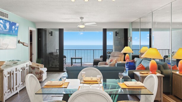 A modern interior with a dining area, sofas, and a view of the ocean. - Watercrest Waves! Beachfront 2br/2ba Condo, Sleeps 8, Stunning Gulf Views! (Panama City Beach)