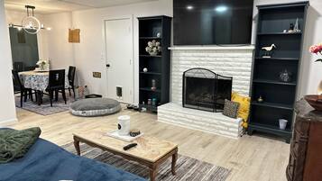Una sala de estar con chimenea, comedor y televisor.