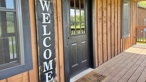 A wooden exterior with a black door and a 'WELCOME' sign. - Escape to the Farm- Minutes from Dale Hollow Lake! (Alpine)