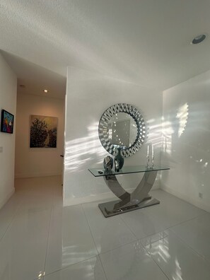 A modern interior with a glass-top table, a decorative mirror, and a vase. - 3-bedroom in Davie . WiFi, AC. Pool ,near to Sawgrass Mall, Hard Rock ,F Garden, (Davie)