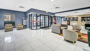A spacious lobby with a revolving door, seating area, and a reception desk.