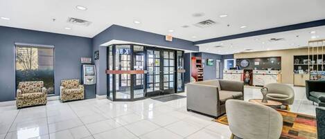 Un'ampia hall con porta girevole, area salotto e reception.
