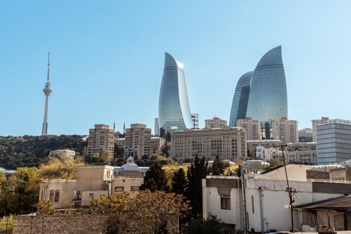 A cityscape with modern buildings, including two prominent skyscrapers with curved designs.