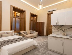 A bedroom with a bed, a bedside table, a nightstand, a sofa, and a wardrobe. - Old City Home By Meridian Hotel (Baku)