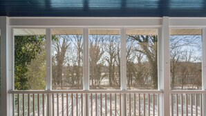 A covered porch with white railings and multiple windows. - Elevated Potomac River Retreat - King Suite - Riverfront - Large Screened Porch (Sharpsburg)