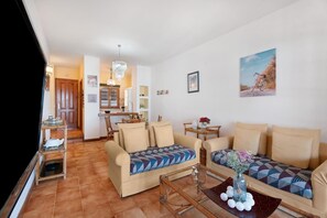 A living room with two sofas, a coffee table, and a dining area with a table and chairs. - Ocean View-2 Bed-sleeps 4-pueblo Marinero (Santiago del Teide)