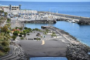 A coastal marina with boats, a rocky shoreline, and a paved walkway. - 3 Bed-room & Wifi-radazul -sea View and Balcony (El Rosario)