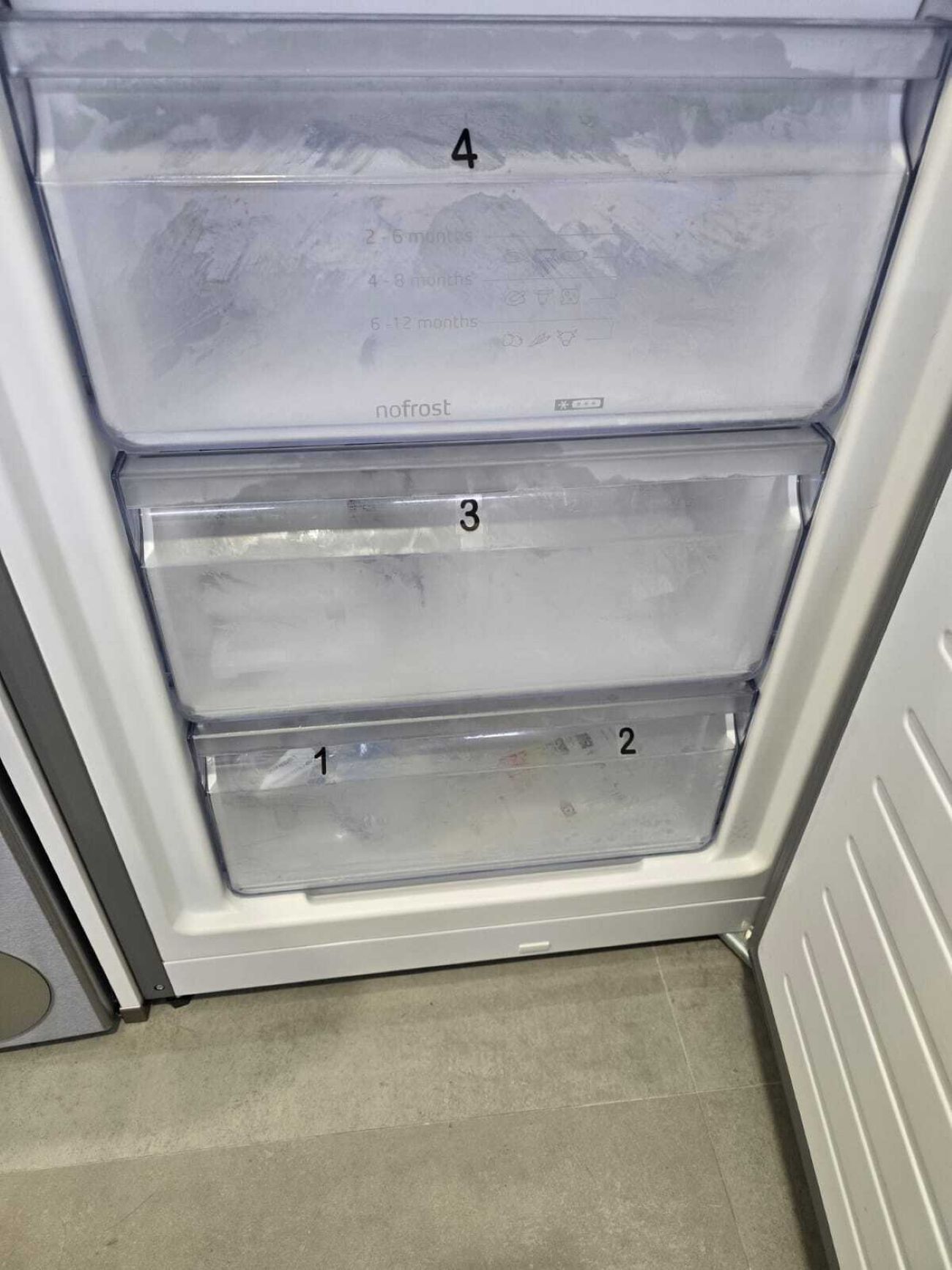 A refrigerator with three transparent shelves, labeled 1 to 4, and a 'nofrost' feature.