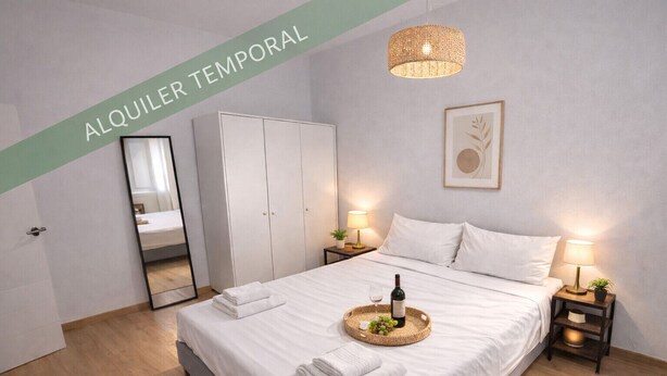 Ein modernes Schlafzimmer mit einem großen Bett, Nachttischen, einem Kleiderschrank und einem Spiegel.