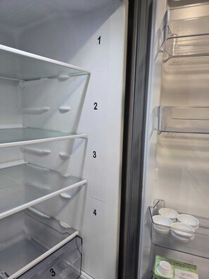 A refrigerator with four shelves and a small compartment at the bottom.