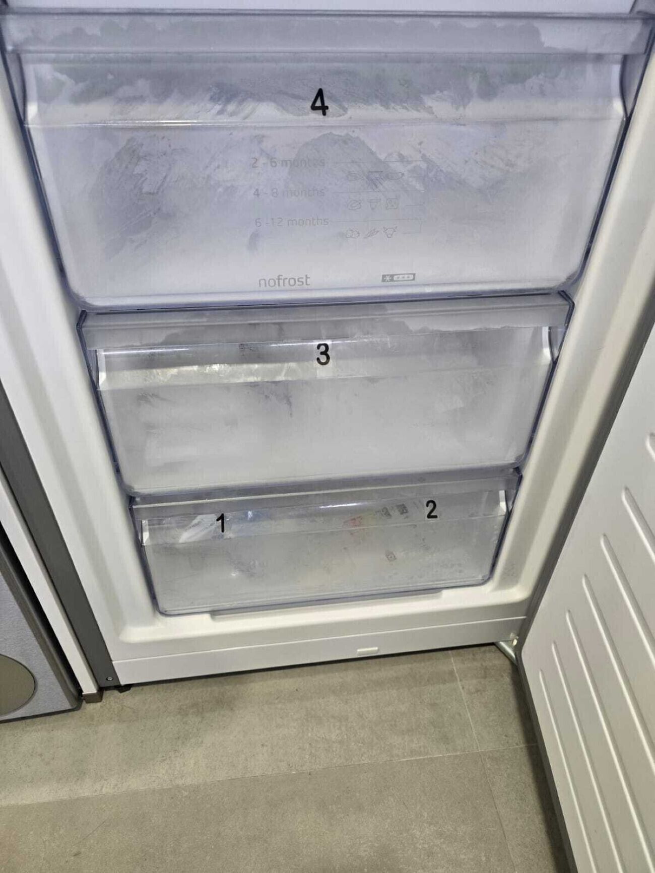 Un frigorífic amb tres prestatges transparents, numerats del 1 al 4, i amb funció 'nofrost'.