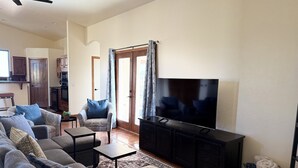 Una sala de estar con un sofá, un televisor y una mesita.